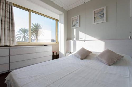 une chambre avec un grand lit blanc et une fenêtre dans l'établissement Residence Saint Marc, à Cannes