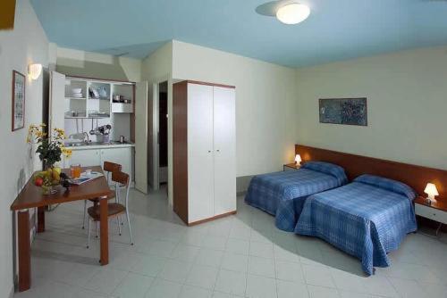 a bedroom with two beds and a desk and a kitchen at Borgo San Martino in Bra