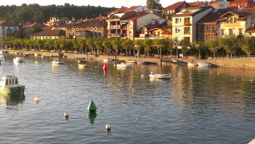 a group of boats in the water near a city at Casa de marinos UribeKosta in Plentzia