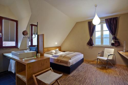 um quarto com uma cama, uma secretária e uma cadeira. em Landgrafen-Mühle em Wallhalben