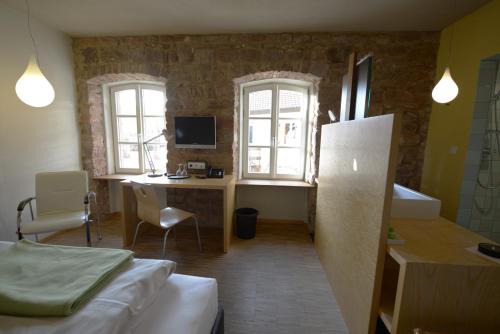 Cette chambre comprend un lit et un bureau avec un ordinateur. dans l'établissement Landgrafen-Mühle, à Wallhalben