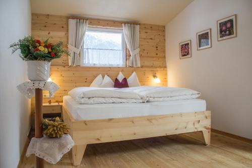 a bedroom with a large bed with a window at Haus Schaller in Valle Di Casies