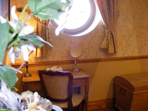 a room with a desk with a chair and a mirror at The Dog and Partridge in Langsett