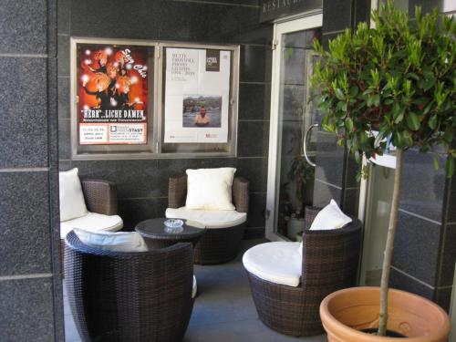 um quarto com cadeiras de vime e um vaso de plantas em Dom Hotel em Linz