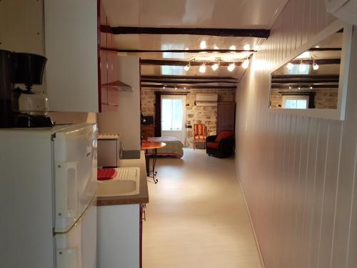 a kitchen with a refrigerator and a dining room at La Bonardière in Gevry