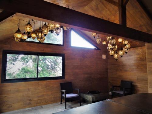 a dining room with chandeliers and a table and chairs at Domaine des Marequiers le Gite Aigremoine in Saint-Germain-du-Teil