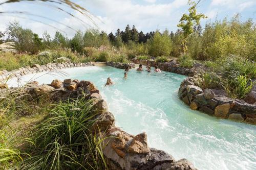 a group of people swimming in a lazy river at Center Parcs Les Trois Forêts in Hattigny