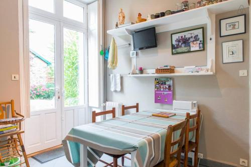 d'une salle à manger avec une table, des chaises et une télévision. dans l'établissement Chambres Saint Donatien, à Nantes