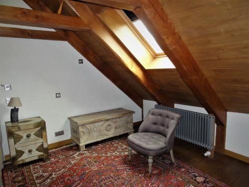 an attic room with a chair and a table at Domaine des Marequiers le Gite Aigremoine in Saint-Germain-du-Teil