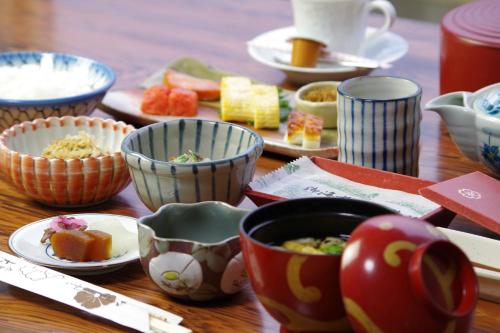 a wooden table topped with bowls and plates of food at Daibutsukan in Nara