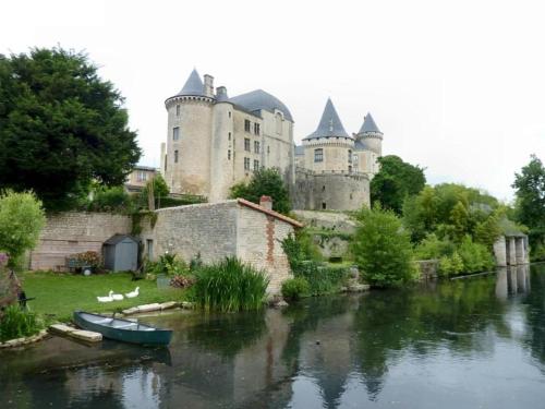 a castle sitting next to a river with a boat at Demeure VERTEUILLAISE in Verteuil-sur-Charente