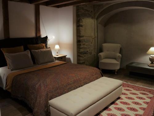 a bedroom with a large bed and a chair at Domaine des Marequiers le Gite Aigremoine in Saint-Germain-du-Teil