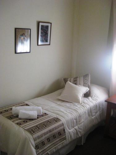 a bedroom with a bed with two towels on it at Hostería Los Gnomos in El Calafate