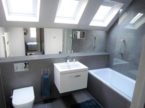 y baño con lavabo, bañera y aseo. en Crown Cottage - Prime Orford Location en Orford