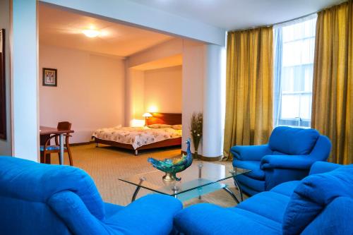 YambolにあるDiana Palaceのリビングルーム(青い椅子、ベッド付)