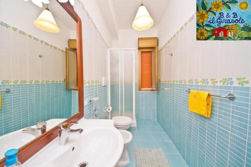 La salle de bains est pourvue d'un lavabo, de toilettes et d'un miroir. dans l'établissement Bed and Breakfast Il Girasole, à Mondello