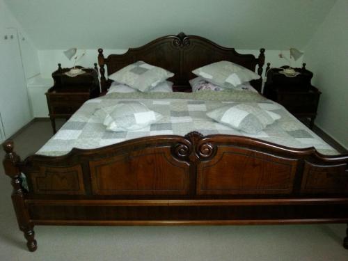 a large wooden bed with white pillows on it at Haus Schönblick in Bad Bertrich
