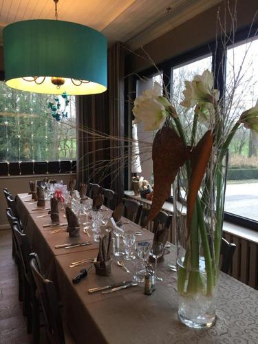 a long table with a vase of flowers on it at Hotel Restaurant Beau Séjour in Morsbronn-les-Bains