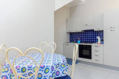 a kitchen with a table and a kitchen with a stove at Casa Red & Blue in Castellammare del Golfo