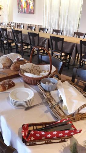 a table with plates and a basket of food at Hotel Restaurant Beau Séjour in Morsbronn-les-Bains