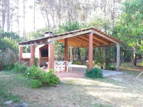 a pavilion with a table and chairs under it at Adi y Dina Cabañas in La Paloma