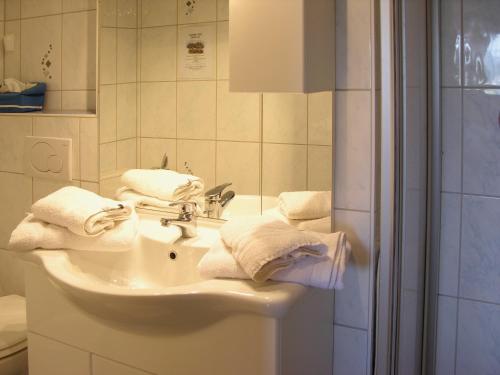 W łazience znajduje się umywalka, lustro i ręczniki. w obiekcie Cafe Rundblick w mieście Baiersbronn