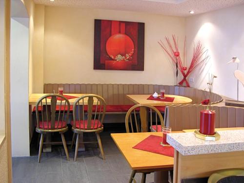 a restaurant with tables and chairs and a painting on the wall at Cafe Rundblick in Baiersbronn