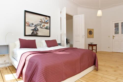 een slaapkamer met een groot bed en een roze deken bij Apartment Prenzlauer Allee in Berlijn