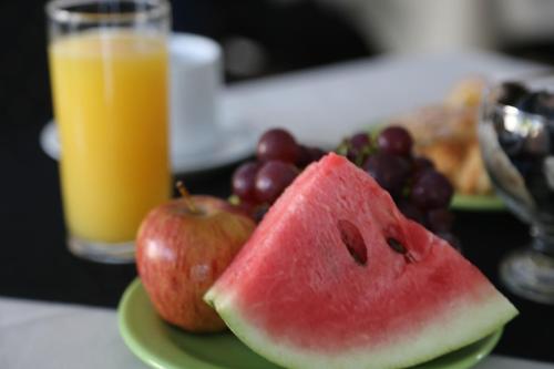 un plato de fruta con una manzana y un vaso de zumo de naranja en Hotel Bulevar, en Paysandú