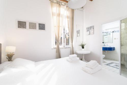 ローマにあるWhite terrace apartment navonaの白いベッドルーム(白いベッド1台、窓付)