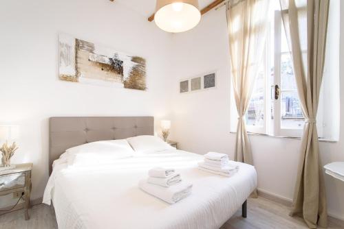 una camera bianca con un letto e una finestra di White terrace apartment navona a Roma