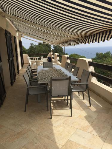 a patio with a table and chairs on a balcony at Maja in Favone