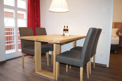 a dining room table and chairs with wine bottles on it at Braumeister Döbler - Ferienwohnungen in Bad Windsheim