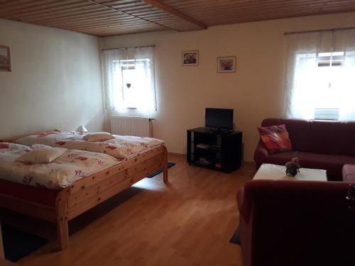 1 dormitorio con 1 cama y 1 sofá en Ferienwohnung Deuerling, en Nurn