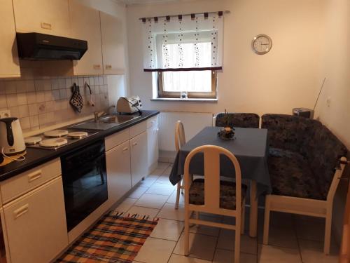 a kitchen with a table and chairs and a kitchen with a sink at Ferienwohnung Deuerling in Nurn