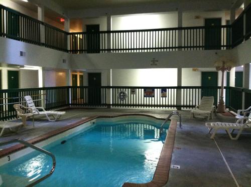 a large swimming pool in a hotel with chairs at Budget Inn Wentzville in Wentzville