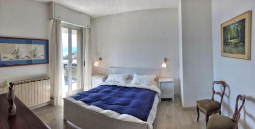 a bedroom with a large bed with a blue blanket at Selva 1 in Ghiffa