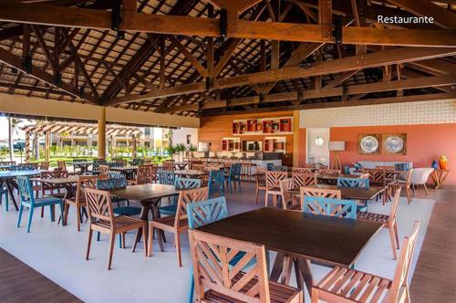 a restaurant with tables and chairs in a room at VG Sun Cumbuco in Cumbuco