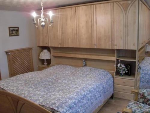 a bedroom with a large bed and a large wooden cabinet at Ferienalm in Ruhpolding