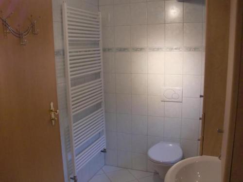 a white bathroom with a toilet and a sink at Ferienalm in Ruhpolding