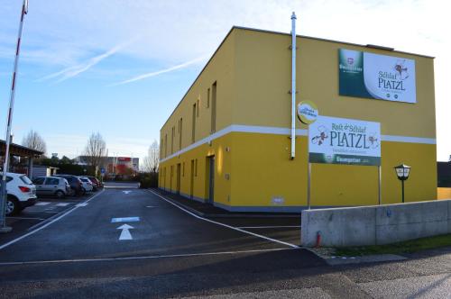 a yellow building on the side of a parking lot at Schlafplatzl in Marchtrenk