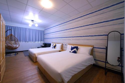 a hotel room with two beds and a painting on the wall at Traveler Station in Kaohsiung