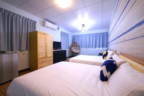 a hotel room with two beds and a television at Traveler Station in Kaohsiung