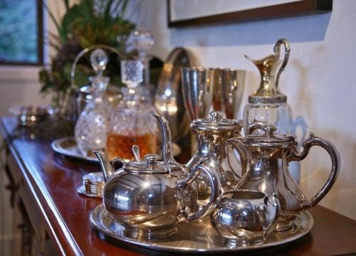 a group of silver tea pots and vases on a counter at Waiorau Homestead in Cardrona