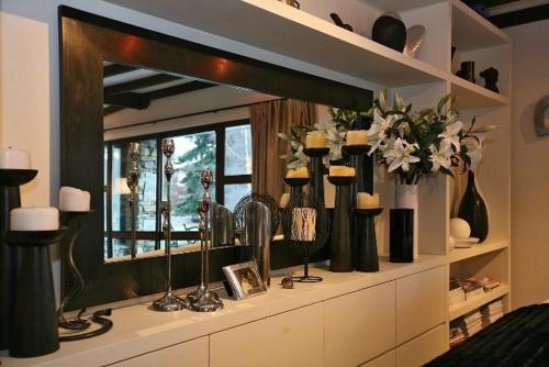 a mirror on a shelf with vases and candles at Waiorau Homestead in Cardrona