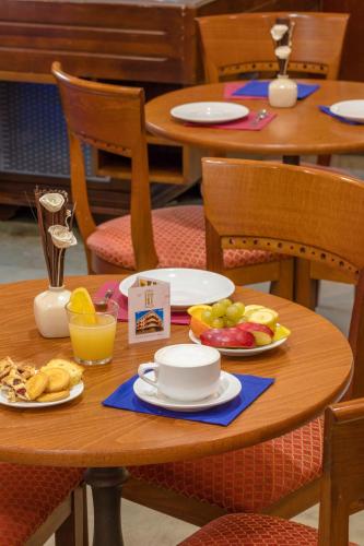 a table with plates of food and fruit on it at Hotel Traiano in Civitavecchia