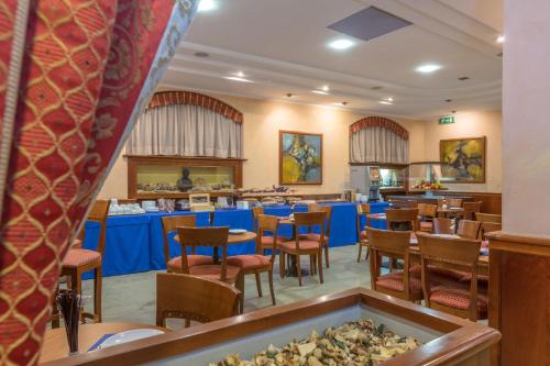 a dining room with tables and chairs in a restaurant at Hotel Traiano in Civitavecchia