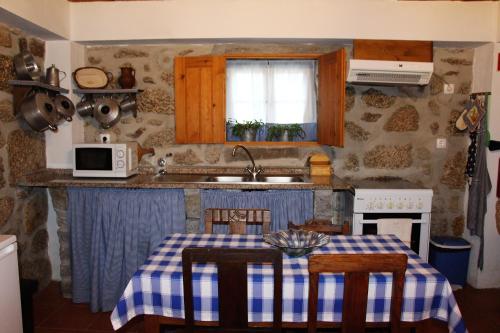 eine Küche mit einem Tisch mit einem blauen und weißen Tischtuch in der Unterkunft Casa d'avó Maria in Seia