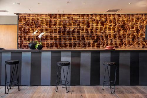 a bar with stools in front of a brick wall at KOS Pilar Hotel in Pilar
