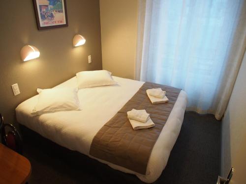 a bedroom with a bed with two towels on it at Hôtel de l'Aviation in La Bourboule